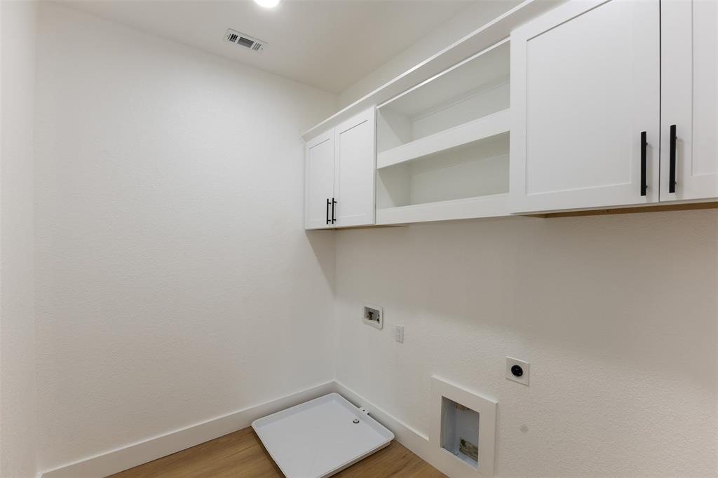 3524 Spring Avenue Dallas, TX 75210 - Photo 25 of 29 Laundry room with washer hookup, light wood-style flooring, electric dryer hookup, cabinet space, and gas dryer hookup