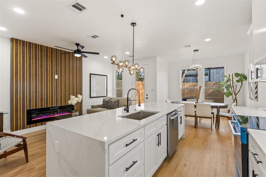 3524 Spring Avenue Dallas, TX 75210 - Photo 10 of 29 Kitchen with an island with sink, white cabinetry, light stone countertops, electric range, and light wood finished floors
