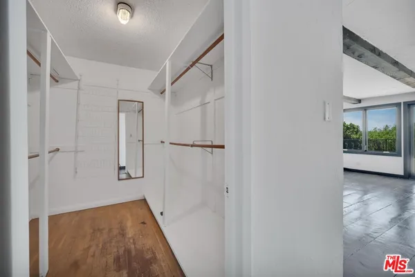 a view of empty room with wooden floor and floor to ceiling window