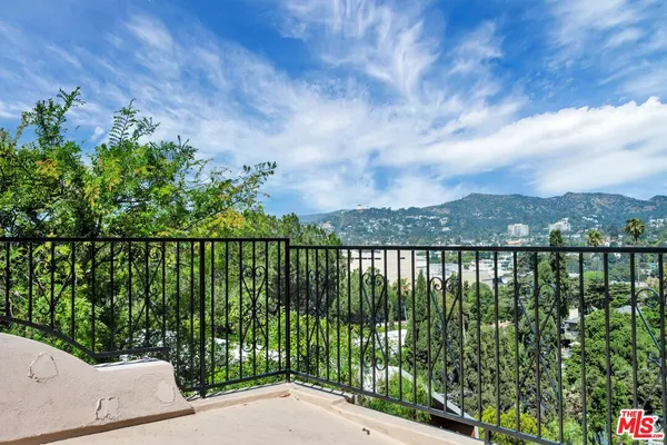 a view of a backyard with plants and a bench