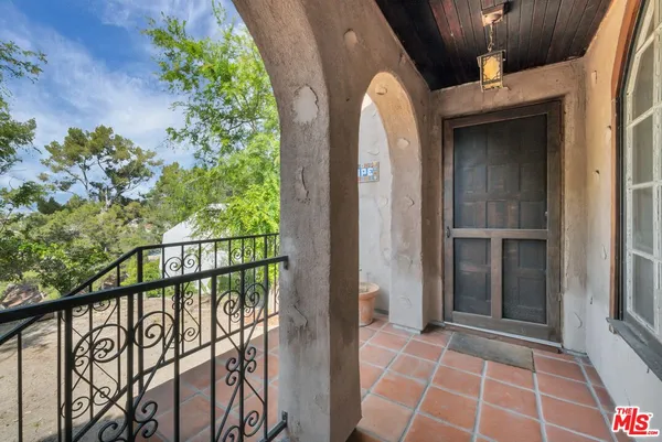 a view of an entryway with wooden floor door mirror and a chandelier