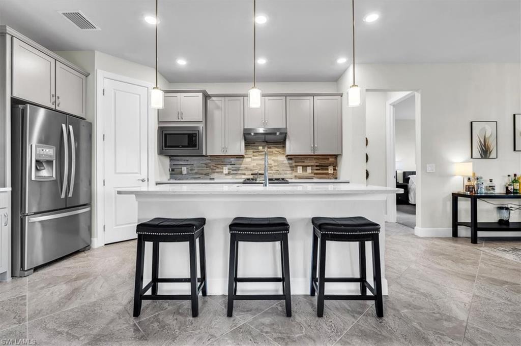 3032 Walnut Grove Lane Alva, FL 33920 - Photo 12 of 49 a kitchen with kitchen island cabinets and chairs