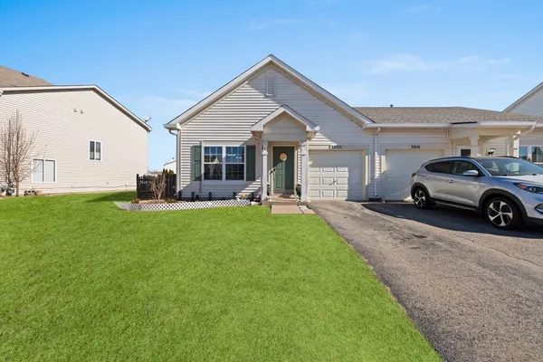 a front view of a house with a garden and plants