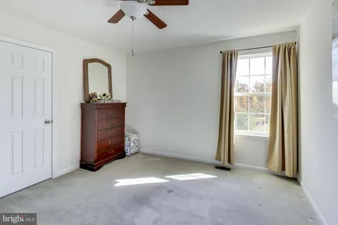 an empty room with windows closet and chandelier fan