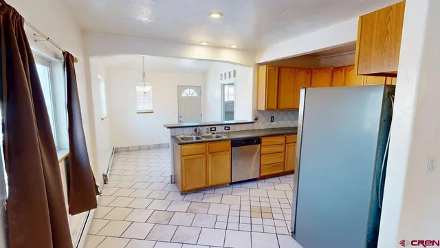 a kitchen with stainless steel appliances granite countertop a refrigerator and a stove