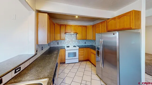 a kitchen with stainless steel appliances granite countertop a refrigerator and a stove top oven