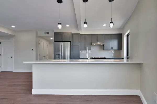 a large kitchen with stainless steel appliances a large counter top a sink and a stove