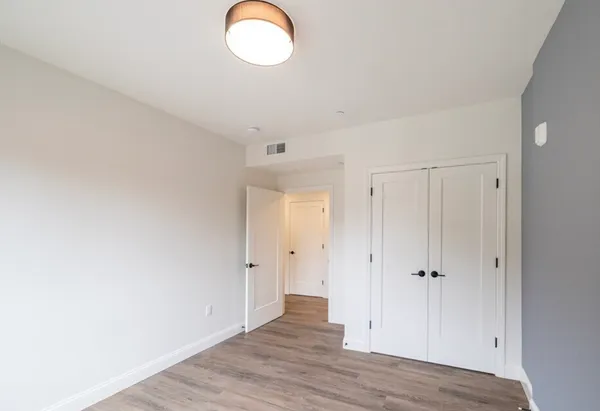 a view of an empty room with wooden floor
