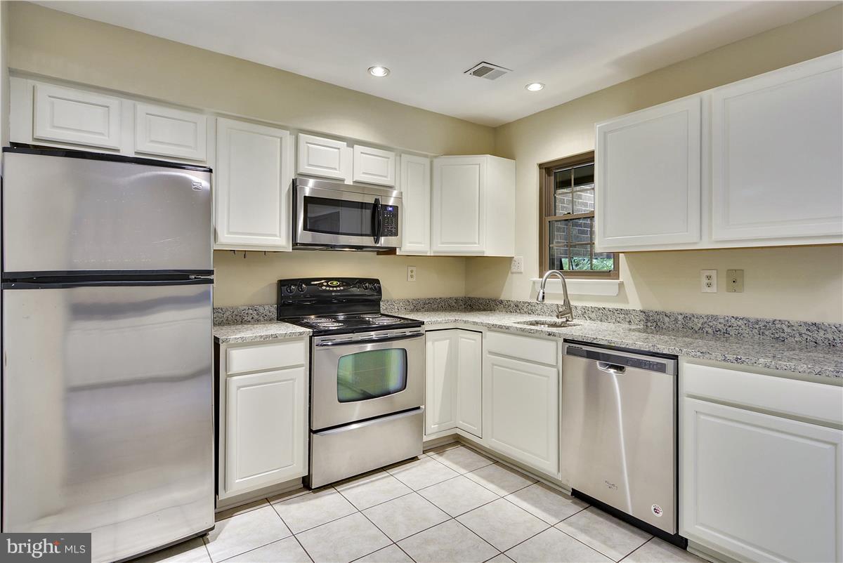 2000 Headlands Circle Reston, VA 20191 - Photo 8 of 23 a kitchen with granite countertop white cabinets and white stainless steel appliances
