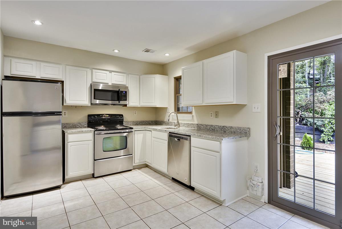 2000 Headlands Circle Reston, VA 20191 - Photo 9 of 23 a kitchen with white cabinets and white appliances