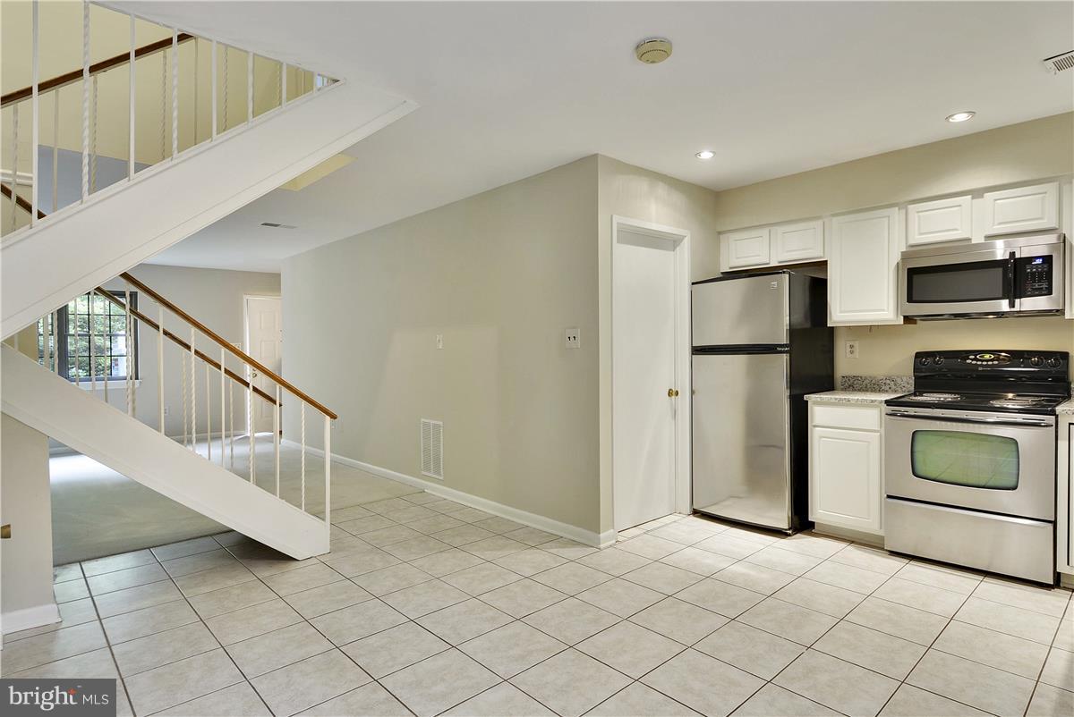 2000 Headlands Circle Reston, VA 20191 - Photo 10 of 23 a kitchen with white cabinets and stainless steel appliances