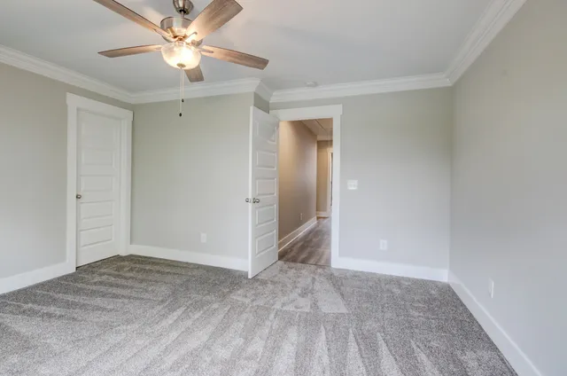 an empty room with closet and a ceiling fan
