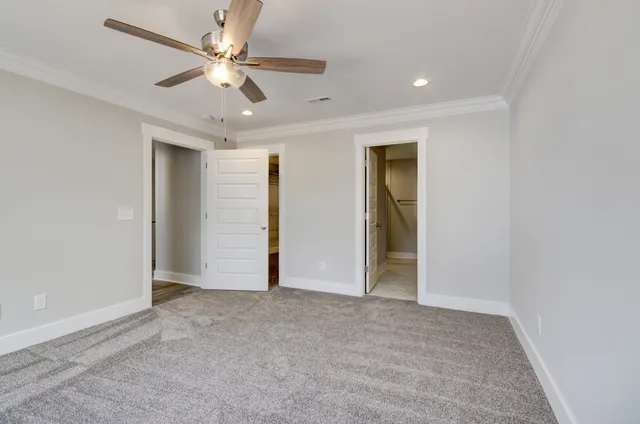 an empty room with closet and a ceiling fan