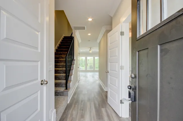 a view of a hallway with wooden floor and staircase