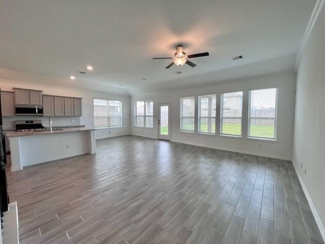 4826 Albany Ridge Lane Rosharon, TX 77583 - Photo 8 of 37 a view of an empty room with wooden floor and a kitchen