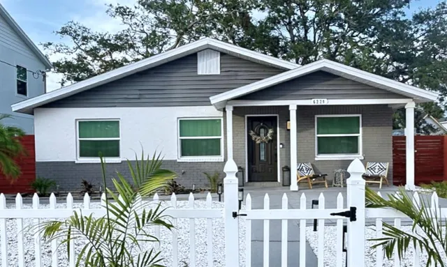 a view of house with a yard and sitting area