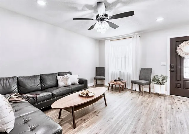 a living room with furniture and a wooden floor