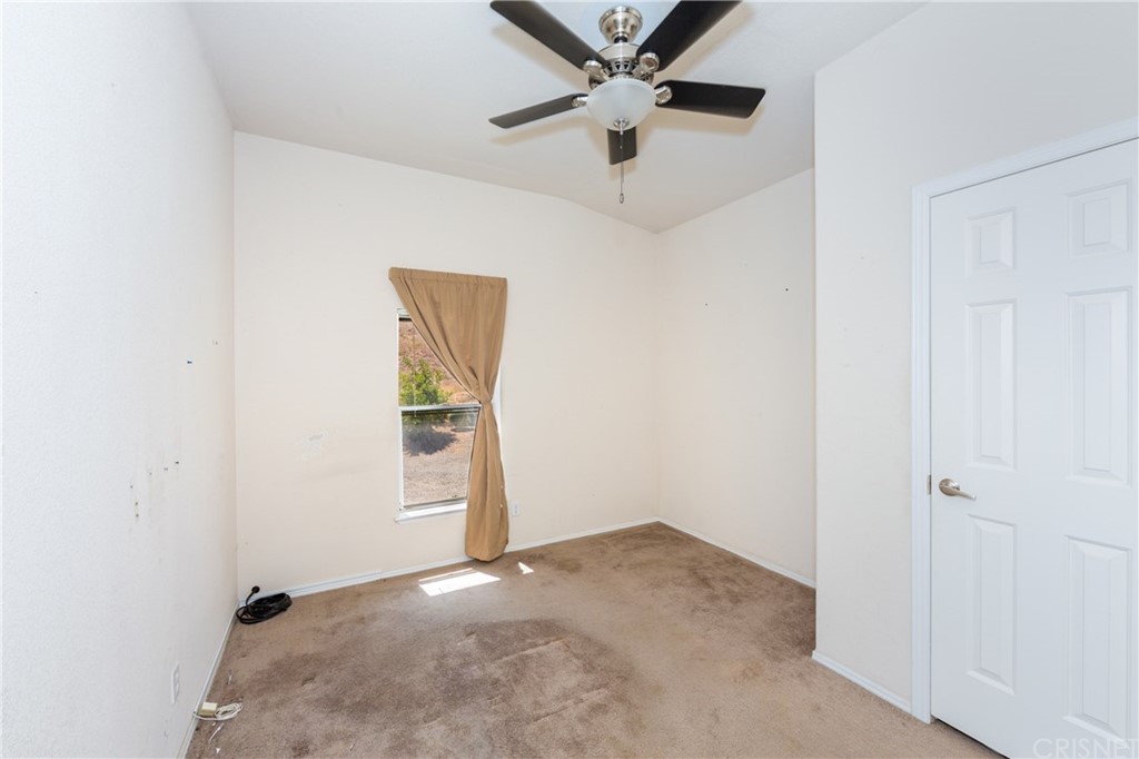 38833 Gorman Post Road Lebec, CA 93243 - Photo 44 of 55 an empty room with a ceiling fan and carpet