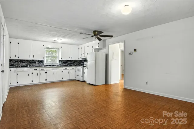 a view of a kitchen with stainless steel appliances a refrigerator and a stove top oven