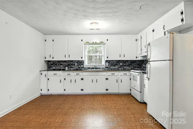 a kitchen with cabinets appliances a sink and a window