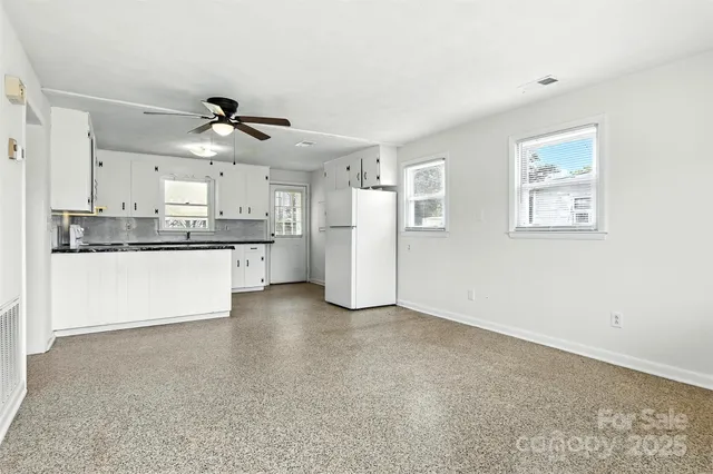 a view of a kitchen with refrigerator and cabinets