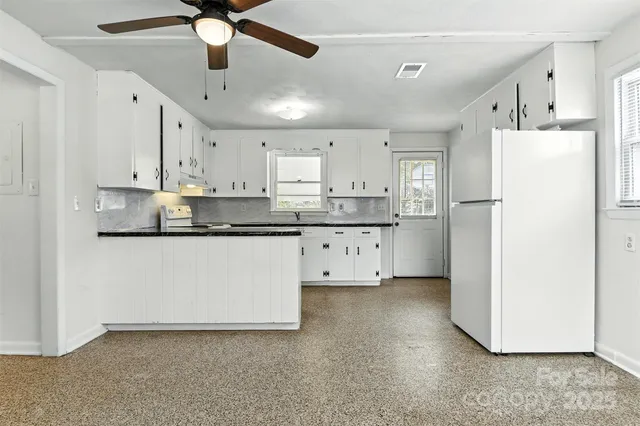 a kitchen with stainless steel appliances a refrigerator sink and white cabinets