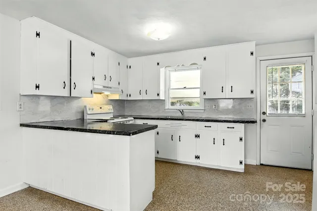 a kitchen with granite countertop white cabinets white appliances with a sink and dishwasher
