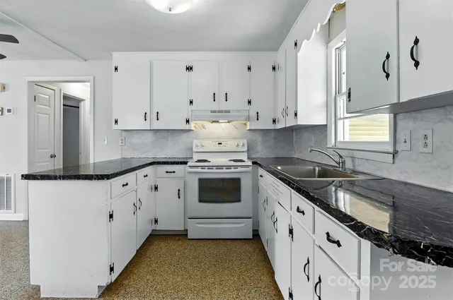 a kitchen with granite countertop white cabinets and white appliances