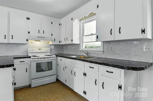 a kitchen with granite countertop white cabinets and white appliances