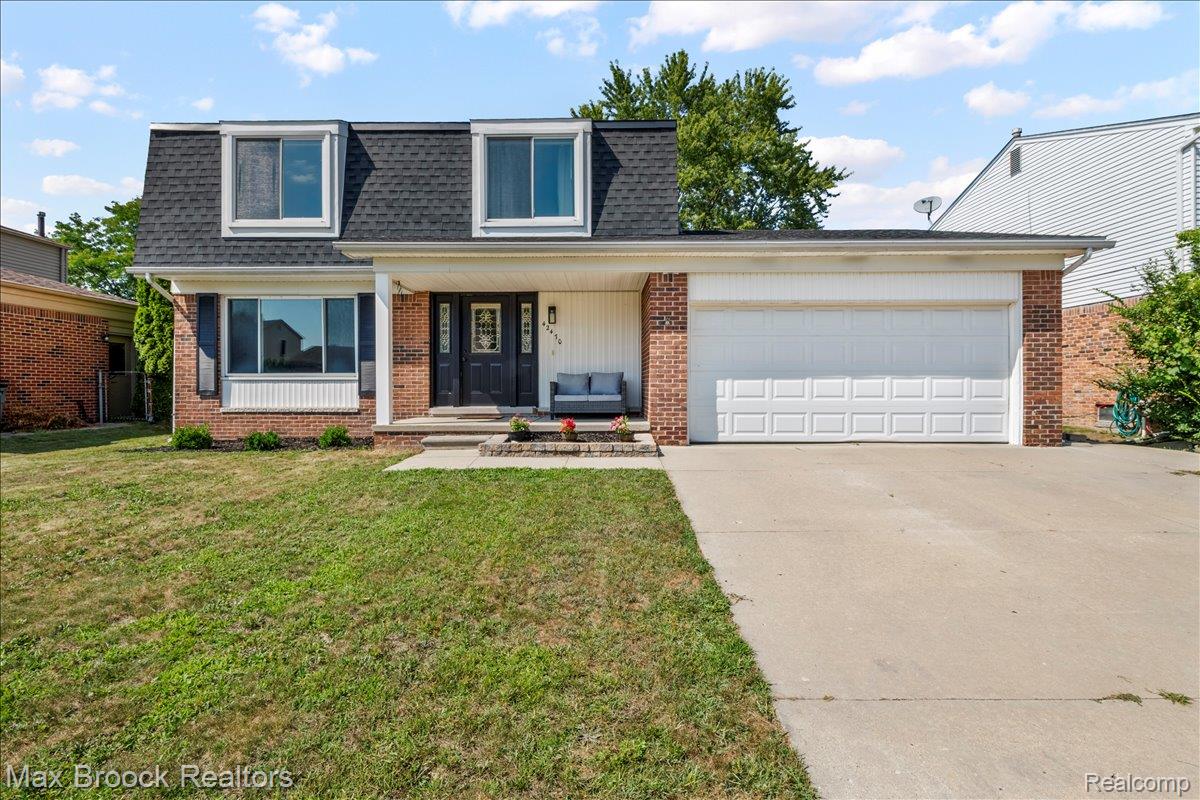 42470 Bishop Road Canton, MI 48188 - Photo 1 of 37 Dutch Colonial exterior featuring a dark asphalt shingle roof, red brick facade, a two-car garage, and a concrete driveway