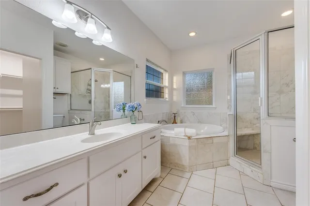 a bathroom with a sink a toilet a mirror and shower