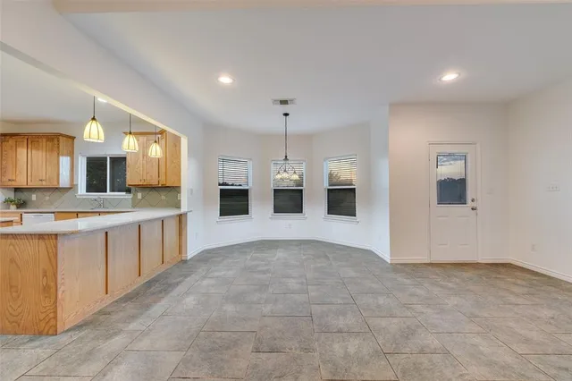 a large white kitchen with kitchen island a sink stainless steel appliances and cabinets