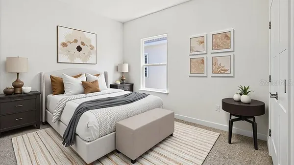 a bedroom with a bed and a lamp on dresser