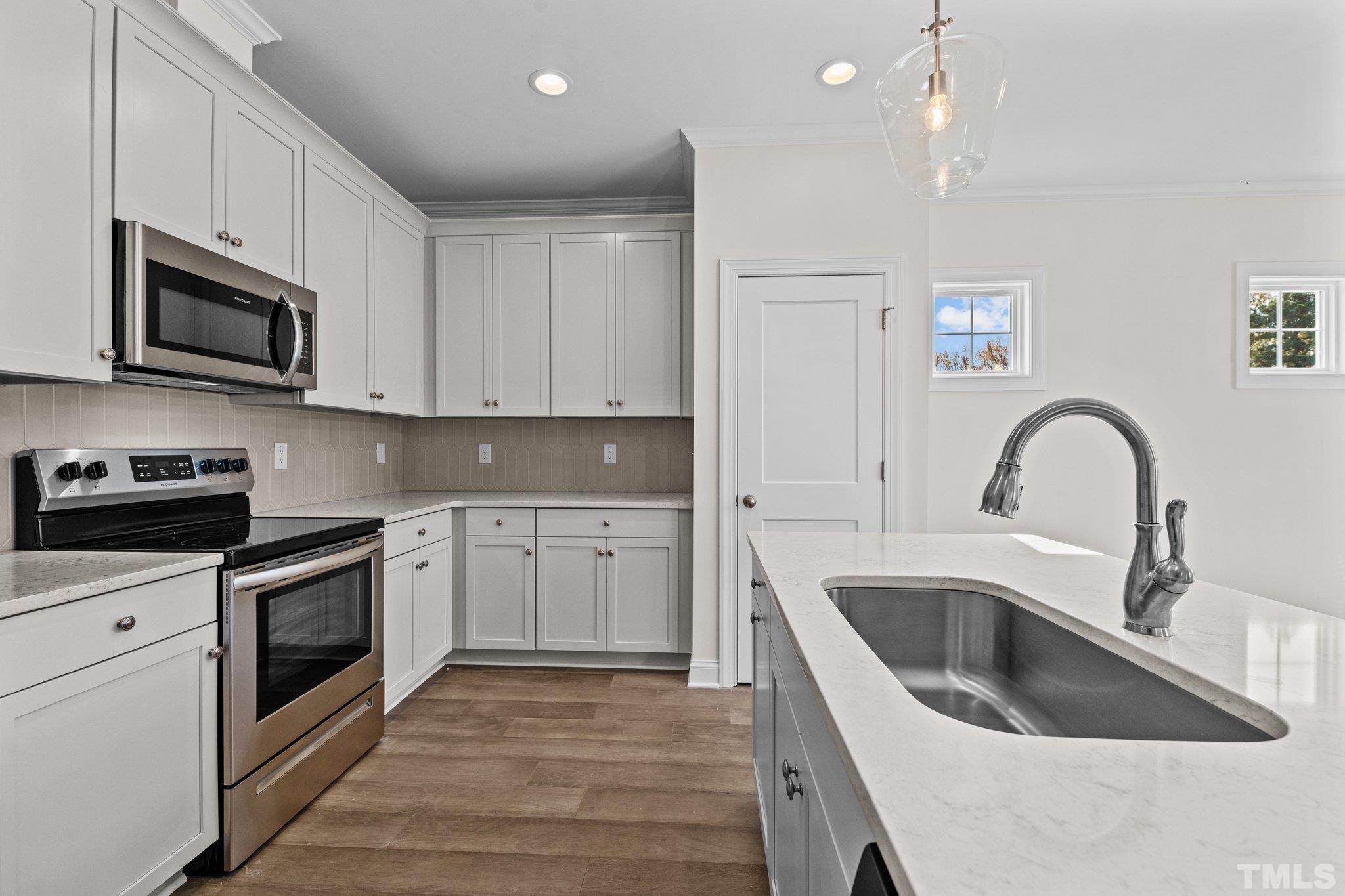 454 Pine Ridge Road Zebulon, NC 27597 - Photo 5 of 42 a kitchen with stainless steel appliances granite countertop a sink a stove top oven and refrigerator