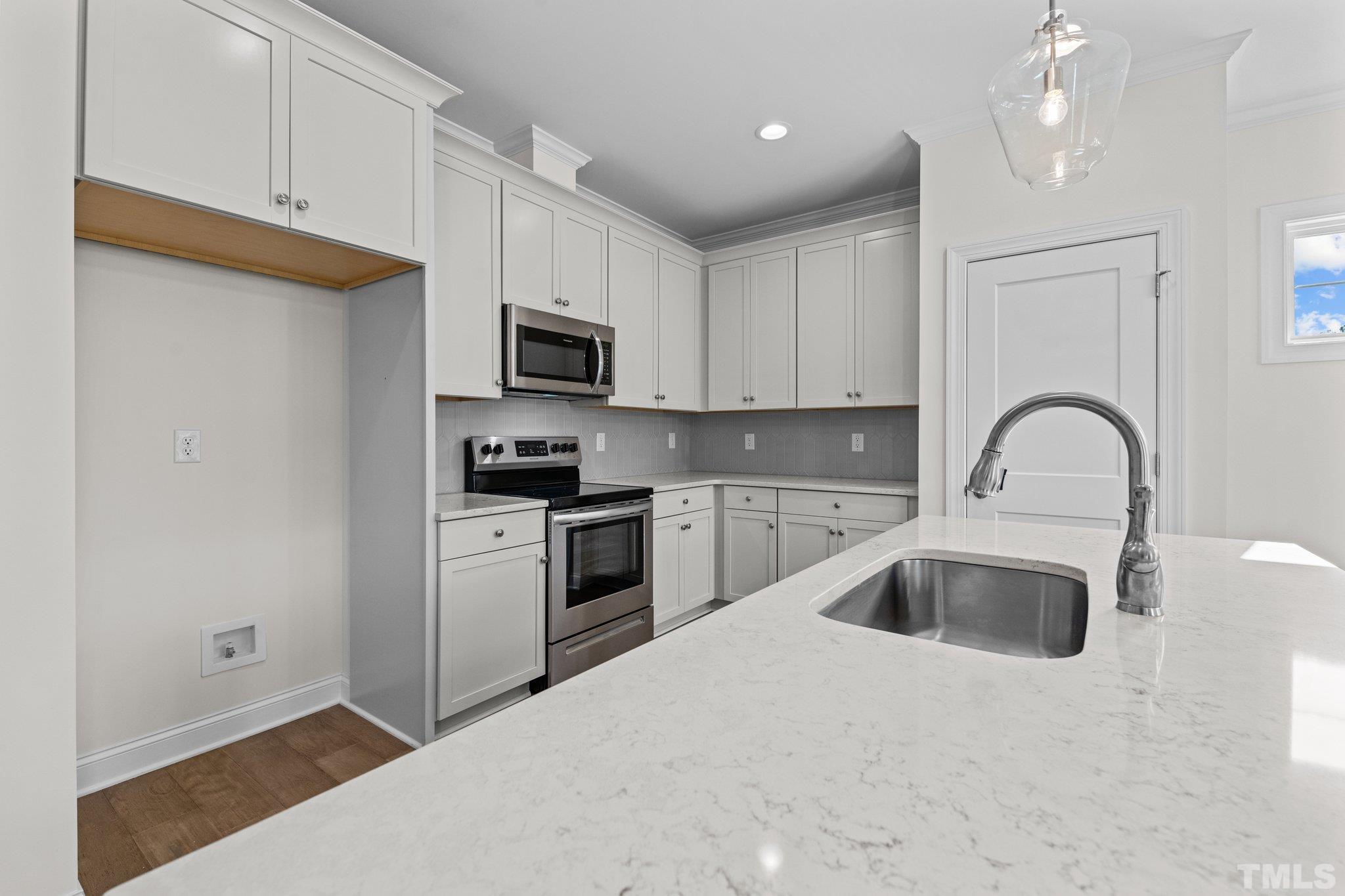 454 Pine Ridge Road Zebulon, NC 27597 - Photo 6 of 42 a kitchen with a sink cabinets and stainless steel appliances