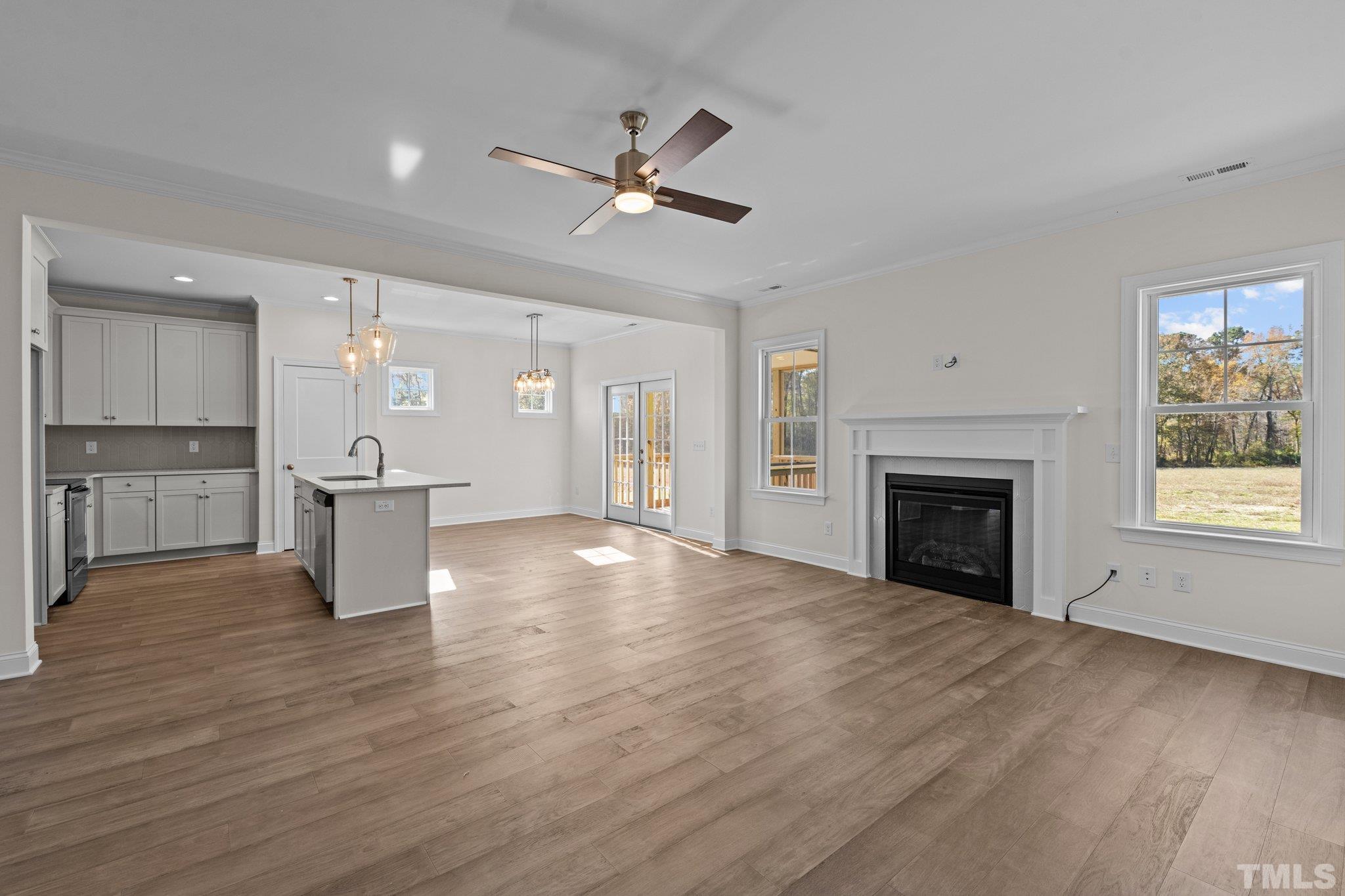 454 Pine Ridge Road Zebulon, NC 27597 - Photo 9 of 42 an empty room with wooden floor fireplace and windows
