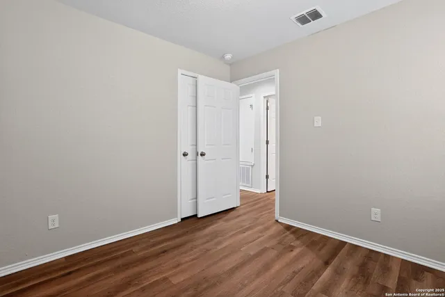 a view of an empty room with wooden floor