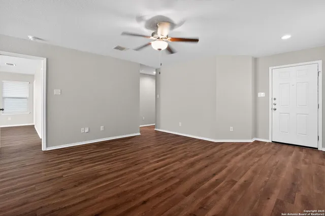 a view of a room with wooden floor and a ceiling fan