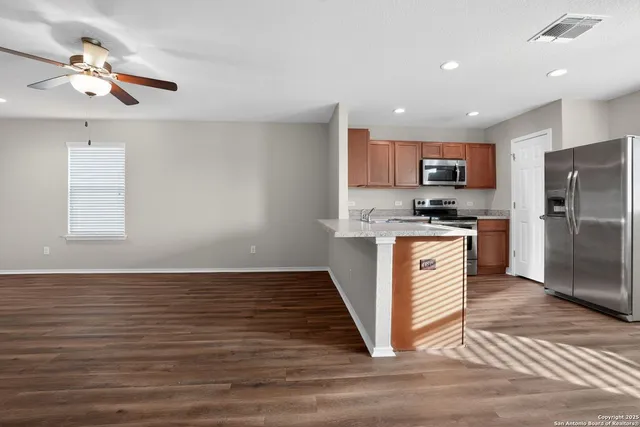 a kitchen with stainless steel appliances granite countertop a refrigerator a stove a sink and a microwave