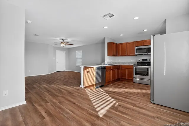 a kitchen with stainless steel appliances granite countertop a refrigerator and a stove top oven