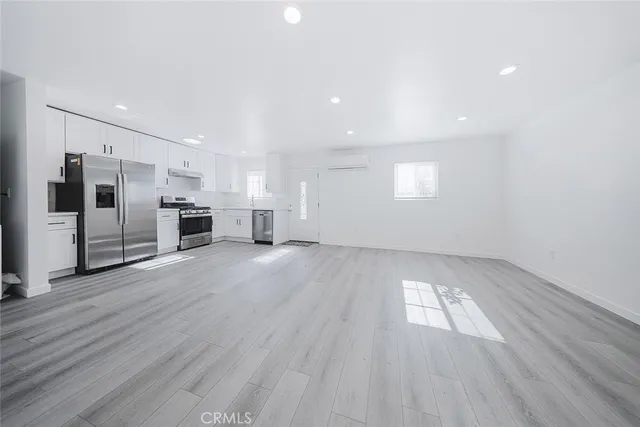 a view of a kitchen with wooden floor and electronic appliances