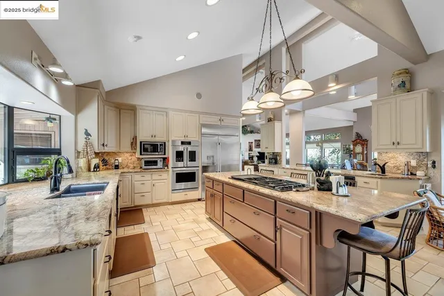a kitchen with kitchen island a counter top space appliances and a cabinets