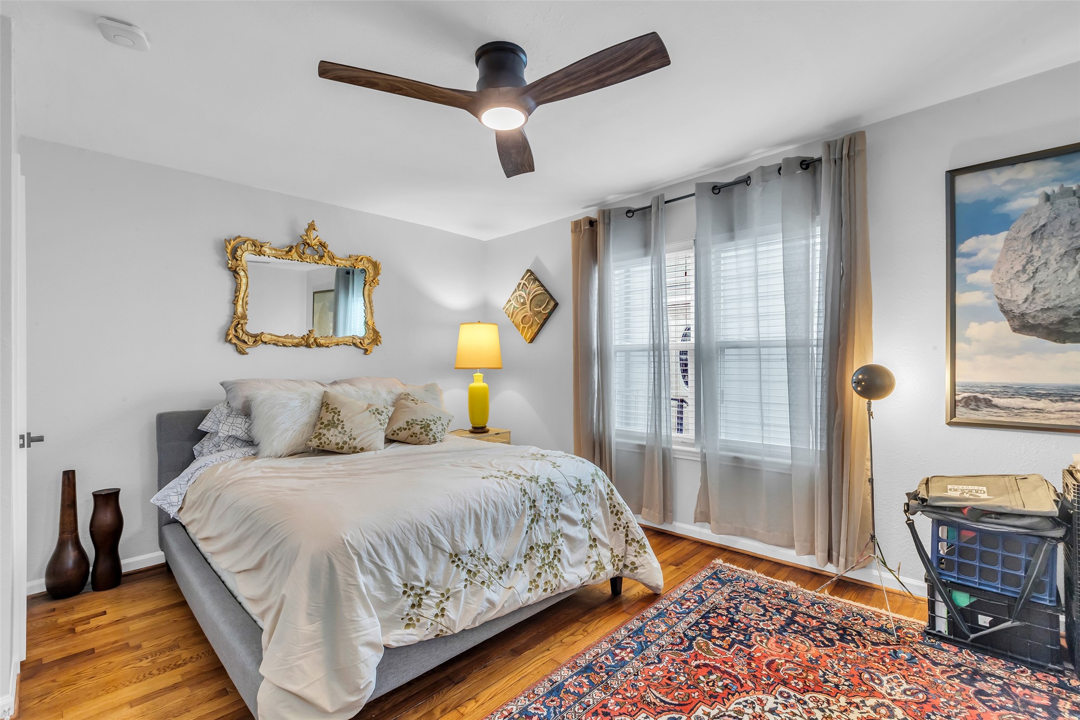 1831 Palm Street Houston, TX 77004 - Photo 18 of 26 This secondary bedroom features a large window that lets in natural light and wooden flooring that adds warmth to the space, creating a comfortable and inviting atmosphere.