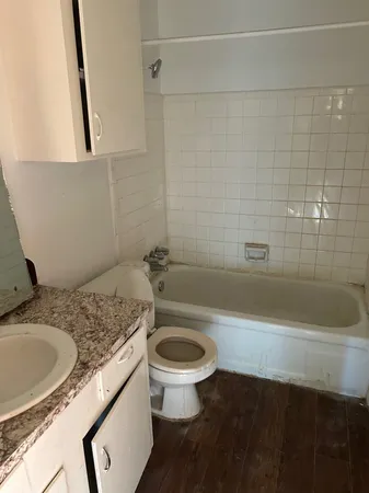 a bathroom with a granite countertop toilet a sink and bathtub