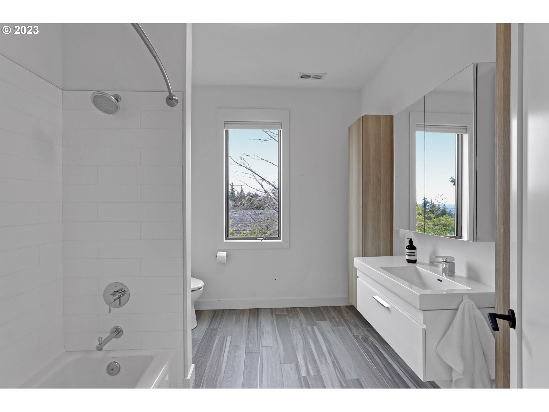 4409 Southwest Carl Place Portland, OR 97239 - Photo 26 of 32 a bathroom with a sink a mirror and a bathtub