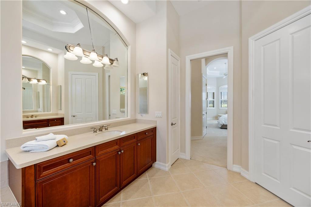 8950 Shenendoah Circle Naples, FL 34113 - Photo 18 of 48 a spacious bathroom with a double vanity sink mirror and double