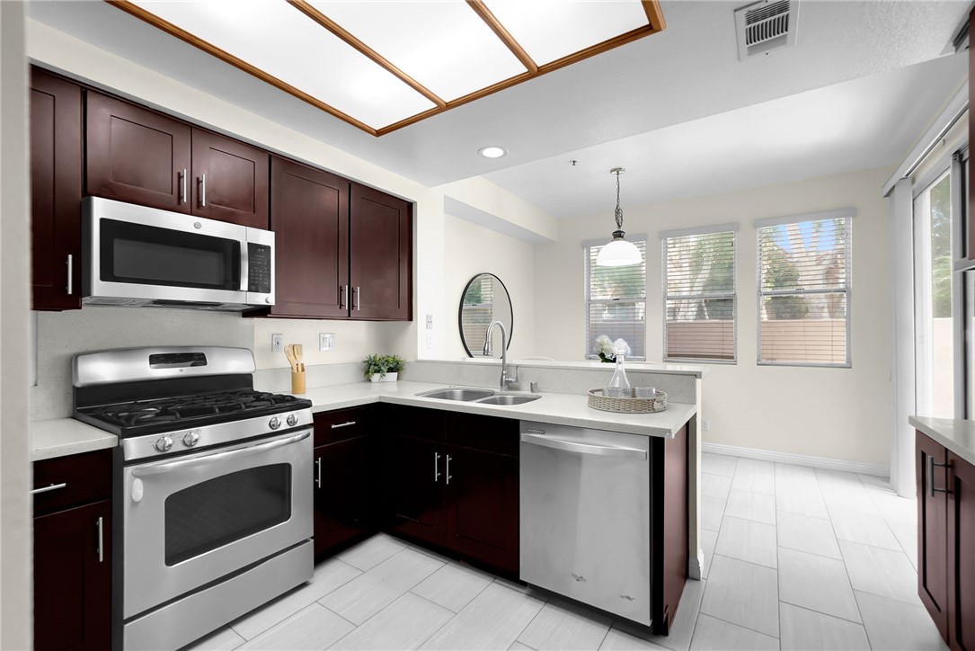 73 Cartier Aisle Irvine, CA 92620 - Photo 7 of 19 a kitchen with a sink stove and microwave