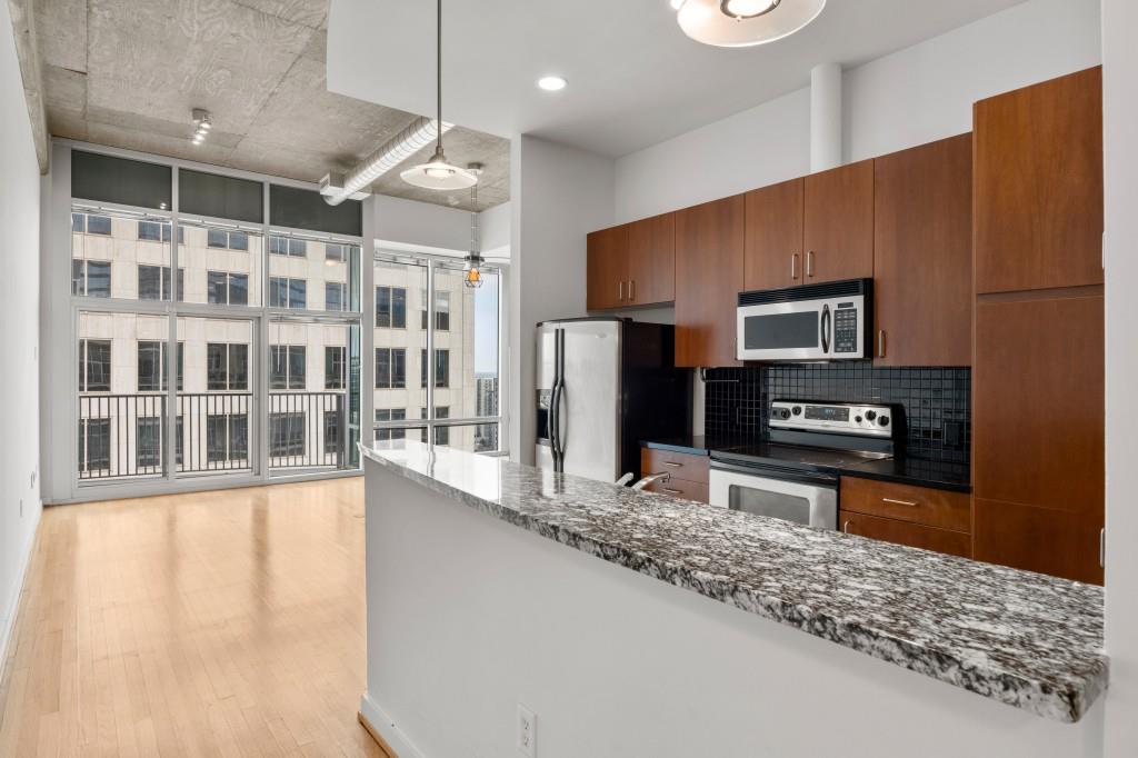943 Peachtree Street Northeast, Unit 2009 Atlanta, GA 30309 - Photo 4 of 57 a kitchen with stainless steel appliances granite countertop a refrigerator a oven and a sink with granite countertops