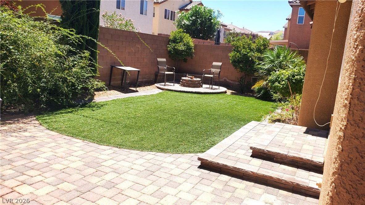 7903 Dell Ridge Avenue Las Vegas, NV 89179 - Photo 18 of 20 A low-maintenance yard showcases an artificial turf lawn complemented by a fire pit lounge area.