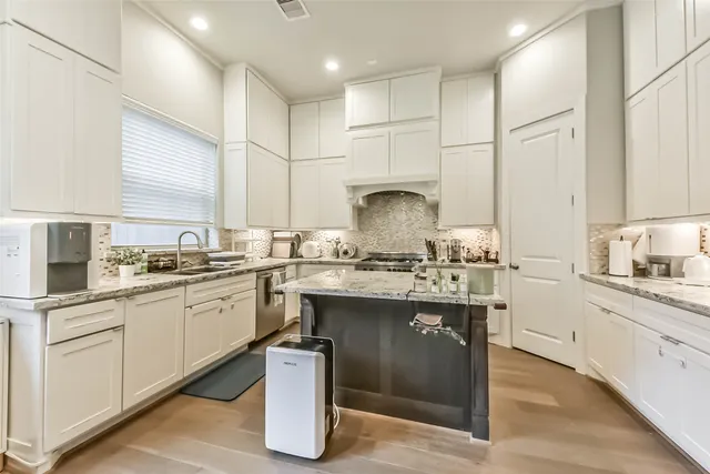 a kitchen with stainless steel appliances granite countertop a sink stove and cabinets